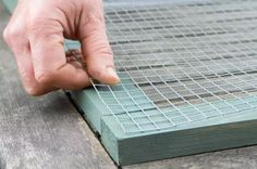 a person's hand on the edge of a piece of wood with grating