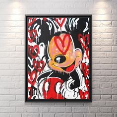 a painting hanging on the wall in front of a brick wall with white and red paint