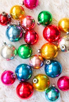 colorful christmas ornaments laying on white fur