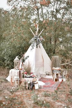 a teepee in the middle of a field with flowers on it and other items