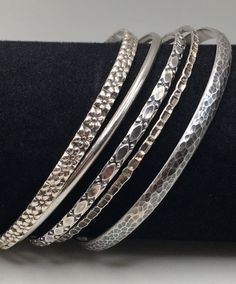 Here are 5 beautiful Pieces Bangles set come with 5 different beautiful patterns. Some bangles are DANCECRAFT .  Wear those 5 together is made you very special. Great pre-own condition. All bangles Stamped "Sterling" or "925" mark inside the bangles. Bangle Measures around: 8 1/2" -8 3/4"  (21.6 cm - 22 cm) 5 Bangles width:  2 mm - 5 mm Total Weight: 36 grams (1.2 Troy Oz)  Item is exactly as shown in pictures.    Please carefully review the item description and accompanying pictures before making a purchase, as we do not offer a return or exchange policy. If you have any questions or require assistance, please do not hesitate to reach out to us.  Check my store link to find more treasures:   https://galaxysilvercity.etsy.com Elegant Sterling Silver Stackable Bracelet, Elegant Silver Stackable Jewelry, Silver Stackable Bangle Jewelry, Handcrafted Silver Bangle, Bangles Silver, Bangles Set, Multi Pattern, Silver Jewelry Fashion, Bangle Set