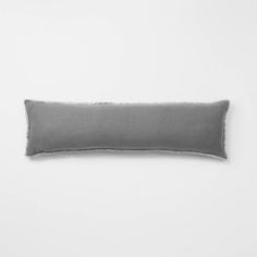 a gray pillow on a white wall