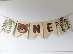 there is a banner that says one with a bear and leaves hanging from the string