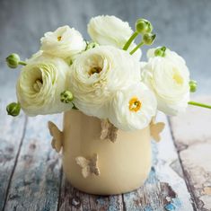 white flowers in a vase on a wooden table