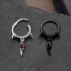 This septum tusk jewelry is mesmerizing. The gothic elements are over the roof. This septum ring features an exquisite design inspired by the graceful and fierce curves of tusks. At the center of the ring sits a vibrant red gem embellished inside a tusk, its deep hue reminiscent of a blood moon gleaming through a cloudy night sky. Get your goth on in gracious style with this septum ring.