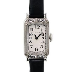 Great Gatsby era Art Deco Tiffany & Co diamond and platinum-topped 18k yellow gold lady's wristwatch white dial with Roman numerals, Tiffany & Co, 15 jewel manual wind Longines movement Swiss no. 4531791 enclosed in a Tiffany and Co diamond and platinum 18k case 8 bezel set round diamonds approximate total weight of .25 - .30 cts. Very good condition - watch currently setting, winding, and running. Watch measures approximately 1 inch by 1/2 inch with new black leather strap base metal buckle. Mi Tiffany And Co Watches Women, Tiffany Watch Woman, Art Deco Platinum Evening Watches, Platinum Art Deco Evening Watches, Art Deco Platinum Diamond Watch In White Gold, Timeless Diamond White Platinum Watch, Art Deco White Gold Platinum Diamond Watch, Evening Platinum Diamond Watch With Polished Finish, Evening White Diamond Watch