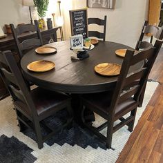 a dining room table with chairs and plates on it