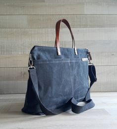 a large blue bag sitting on top of a wooden floor next to a white wall