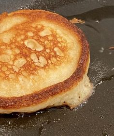 a close up of a pancake on a stove with oil coming off the top