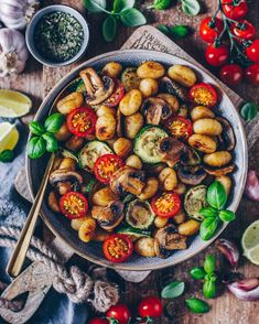 a bowl filled with vegetables on top of a wooden table next to other food items