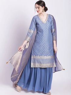 This timeless ensemble showcases the classic beauty of blue banarasi chanderi with luxurious zari work. Included is a kurta, an elegant georgette sharara, and a two tone organza dupatta, perfect to add a sophisticated touch to any occasion. No. of pieces - 3 piece set. Color - Blue. Fabric - Banarsi Chanderi, Georgette and Organza. Kurta Length - 40 inches. Washing Instructions - Dry Clean. Organza Suits Indian, Indian Designer Suits Party Wear, Banarasi Suit Designs, Suit Designs Indian Style, Organza Kurta, Kurta And Sharara, Georgette Sharara, Indian Sari Dress, Indian Designer Suits