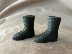 a pair of black boots sitting on top of a bed