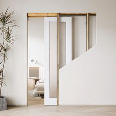 an open door leading to a bedroom with a plant next to it and a bed in the background