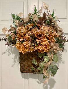 a basket filled with lots of flowers sitting on top of a door