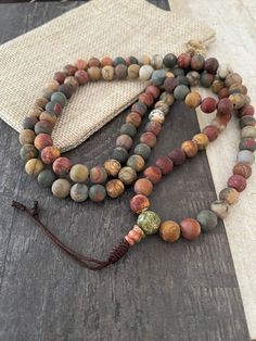 Matte Jasper mala necklace, a unique unisex earthy 108 mala necklace that you can rock with your everyday outfit, can be a layering necklace and you can use it also while meditating. A unisex item that is a great gift for yourself and a love one. The mala necklace has a drop lenght of: 17 inch  (without the tassels) ,  No Clasp. A most have addition to your gemstone jewelry collection. ⚡️GET 20% OFF NOW⚡️ JOIN AKASHI'S VIP LIST and Shop ⚡️Join Akashi's VIP list for early bird discount access⚡️ P Bracelet Picture, Mala Beads Bracelet, 108 Mala Beads, Jasper Necklace, Mala Bracelet, Mala Necklace, Picture Jasper, Early Bird, Layering Necklace