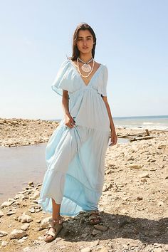 Forever free and flowy, this effortless maxi dress from our free-est collection is featured in a V-neck, tiered silhouette with flutter sleeves for added shape. * Soft, textured fabrication * Elastic empire waist * Effortless, pull-on style | La La Maxi Dress by free-est at Free People in Blue, Size: S Luxury Vacation Maxi Dress With Smocked Bodice, Cheap Blue Short Sleeve Maxi Dress, Long Cotton Maternity Dress, Long Flowy Dress Casual, Summer Baby Shower Outfit, Free People Maternity, Funny Reference, Blue Beach Dress, Maternity Fits