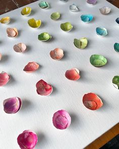 there are many different types of paper flowers on the table top, including one that has been rolled up