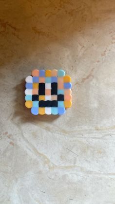 a small colorful object sitting on top of a white counter next to a brown wall