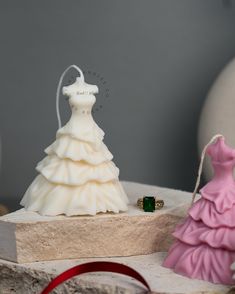 a wedding dress and ring sitting on top of a stone slab next to a christmas tree ornament