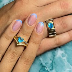 a woman's hand with two rings on top of her and one ring in the middle