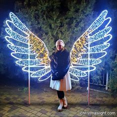 a woman standing in front of a lighted angel