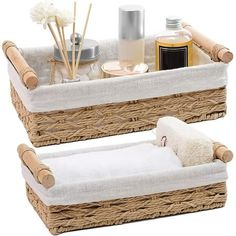 two wicker baskets with towels, soaps and other items in them on a white background