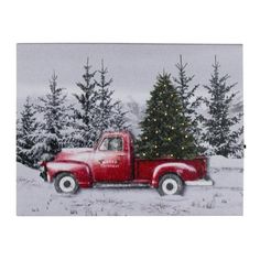 a red truck with a christmas tree on the back in front of some pine trees