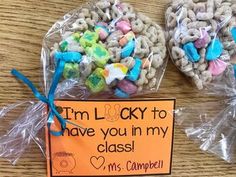 two heart shaped cookies with candy in them sitting on a wooden table next to a sign that says i'm lucky to have you in my class