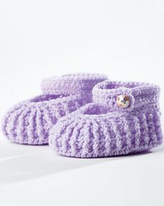 there is a pair of purple knitted baby shoes