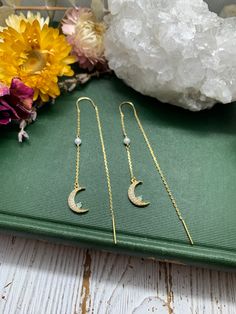 "Fine and delicate, these earrings flow from the earlobe in a beautiful gold line. Length can be adjusted depending how far the chain is pulled through the ear. These threader earrings measure 50 mm in length. Hanging from one end of the chain is an opal crescent moon, filled with cubic zirconia. Threader earrings come with wire ends to make it easy to thread the chain through any pierced hole of your ear, making these earrings fun to wear and play around with (from one pierced hole to another). Dainty Moon Phase Earrings, Dainty 14k Gold Filled Threader Earrings, Dainty 14k Gold Threader Earrings, Black Oak Tree, Gold Threader Earrings, Moon Earring, Threader Earrings Gold, Earring Gold, Gold Line