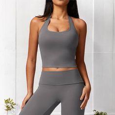 The Anna-Kaci Women's Ribbed Halter Neck Sports Bra with Built-In Bra is a stylish and functional piece perfect for your casual and active wardrobe. Made from soft, stretchy ribbed fabric, this Sports Bra features a flattering halter neck design that accentuates the shoulders and offers a chic, sporty look. The built-in bra provides added support and comfort, making it ideal for low-impact activities or everyday wear. The cropped length pairs beautifully with high-waisted jeans, leggings, or ski Gray High Stretch Casual Sports Bra, Solid Color Activewear For Gym, Fitted Solid Color Activewear For Workout, Fitted Solid Color Athleisure Activewear, Casual Solid Color Activewear For Gym, High Stretch Solid Color Activewear For Workout, High Stretch Solid Color Activewear For Sports, Sporty High Stretch Solid Color Activewear, Fitted Solid Color Sporty Activewear