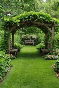 a wooden bench sitting under a pergoline covered in greenery and flowers on a lush green lawn