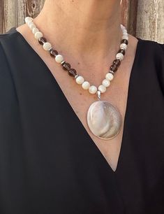 This stunning mother of pearl conch shell fossil pendant necklace is the perfect accessory for those who appreciate unique and one-of-a-kind jewelry pieces.  This necklace is not only a beautiful fashion statement, but also a historical piece of nature's artistry preserved through time.  Add this distinctive piece to your collection or gift it to a loved one who cherishes the beauty of nature's creations. Select your desired necklace length from the drop down menu. Please note as necklaces are m Elegant Shell Pendant Necklace For Beach, Unique Shell-shaped Mother Of Pearl Jewelry, Unique Mother Of Pearl Shell Pendant Necklace, White Mother Of Pearl Pendant Shell Necklace, Elegant Pendant Shell Necklace For Beach, Elegant Adjustable Abalone Shell Necklace, Elegant White Shell Necklace With Natural Stones, Spiritual Mother Of Pearl Pendant Necklace, Unique Mother Of Pearl Shell Jewelry