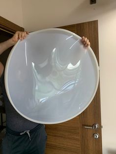 a man holding up a large white bowl