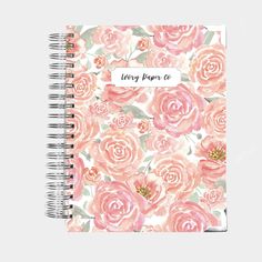 a spiral notebook with pink flowers and the words living paper co written in white ink