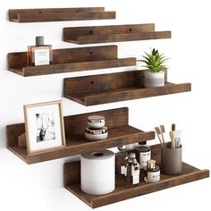 three wooden shelves with various items on them and a potted plant in the middle