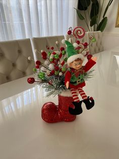 an elf is sitting on top of a boot with christmas decorations and candy canes