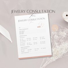 the jewelry consolation form is next to some dried flowers and a white ribbon