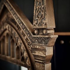 an ornate wooden bed frame with carvings on it