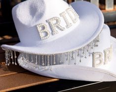 Gather your bridal party and get ready for some fun with our Bride Cowboy Hat with Pearls! This unique and stylish hat is the perfect accessory for any bachelorette party or bridal shower, ensuring the bride-to-be stands out. Features: Chic cowboy hat adorned with elegant pearlsComfortable fit for all-day wearIdeal for bachelorette parties, bridal showers, and bridesmaids proposalsThis hat is a great way to add a touch of western flair to your celebrations. Whether you’re hitting the town with y Bride Cowboy Hat, Hat With Pearls, Mens Pjs, Themed Bridal Shower, Kids Robes, Womens Pjs, Girls Holiday Dresses, Holiday Dress Outfit, Party Look