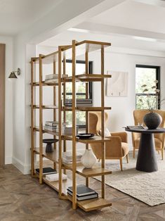 a living room filled with furniture and a book shelf next to a dining room table