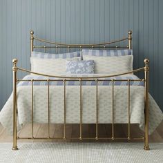 a metal bed with blue and white sheets