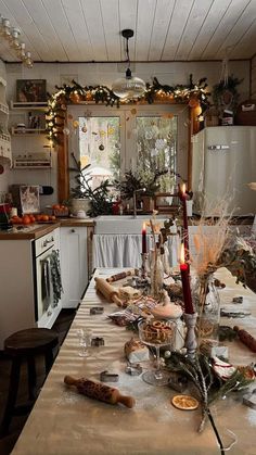 a table is set for christmas dinner with candles and food on the dining room table