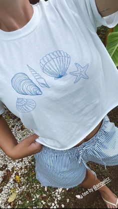 Seashells by the sea shore...wishing I was at the beach collecting shells but this will do! 🐚 - Comfort Colors - White or Ivory with blue seashells design - Model is wearing Ivory - Gets cozier the more you wear it! - 100% ring-spun cotton - soft-washed, garment-dyed fabric - Heavy fabric (6.1 oz/yd²) - Relaxed fit - Sewn-in twill label The soft-washed, garment-dyed fabric brings extra coziness to your wardrobe while the relaxed fit makes it an excellent daily choice. The double-needle stitching throughout the tee makes it highly durable while the lack of side seams helps the shirt retain its tubular shape. Nautical Short Sleeve Beach Top, White Nautical Tops For Vacation, Nautical Beach Tops For Summer, Nautical Style Beach Tops For Summer, Nautical Tops For Beach In Summer, Casual Ocean Color Beach Tops, Casual Ocean Color Tops For Beach, Nautical Blue Top For Beach, White Beachy Top For Beach Party