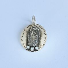 Please allow 10-14 weeks for this item to be custom made Sterling silver hammered disc pendant with Guadalupe and Mother of Pearl Designed by Richard Schmidt Silver Hammered Oval Pendant Jewelry, Silver Our Lady Of Guadalupe Necklace, Silver Our Lady Of Guadalupe Pendant Jewelry, Silver Hammered Amulet Jewelry, Richard Schmidt, Mother Of Pearl Pendant, Pearl Design, Disc Pendant, Hammered Silver