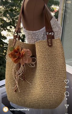 a woman holding a straw bag with flowers on it