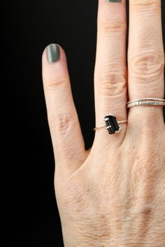 A stunning piece of Raw Black Tourmaline is showcased in a custom built, Sterling Silver prong setting. This piece - while delicate in design - makes a bold statement through the contrast of the bright metal against the deep black of the tourmaline stone. Minimalist Black Emerald Cut Jewelry, Black Tourmaline Rings As Gifts, Black Tourmaline Rings For Gift, Black Tourmaline Gemstone Rings, Modern Black Sapphire Ring, Black Tourmaline Jewelry As Gift, Black Tourmaline Jewelry Gift, Raw Black Tourmaline, Tourmaline Stone