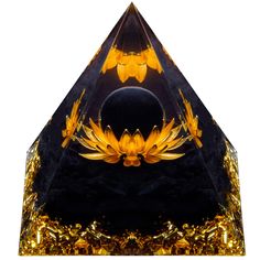 a black and gold triangle shaped object with an orange flower on the center, surrounded by golden flakes