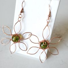 Unique Copper Flower Jewelry, Green Wire Wrapped Metal Earrings, Nature-inspired Copper Earrings As Gift, Adjustable Copper Flower Earrings, Bohemian Wire Wrapped Flower Jewelry, Handmade Copper Gold Flower Earrings, Handmade Gold Flower Earrings In Copper, Bohemian Flower-shaped Wire Wrapped Jewelry, Adjustable Green Flower Shaped Jewelry