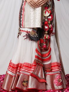 Garad Angrakha Lehenga - Inspired by gauri(durga), this lehanga set brings elements of akalbodhan, translating to the untimely awakening of Durga. The set features a gota bralette, an angrakha jacket and a full-pleated skirt, making it a perfect royal garment for your special occasions. Traditional Pre-draped Saree With Sheer Dupatta For Navratri, Traditional Ceremonial Pre-draped Saree With Cutdana, White Pre-draped Saree With Gota Work For Navratri, Transitional Pre-draped Saree With Cutdana For Traditional Ceremonies, Traditional Raw Silk Lehenga With Gota Work, Bollywood Style Pre-draped Saree With Tilla For Navratri, Bohemian Pre-draped Saree For Festivals And Ceremonies, Festive Pre-draped Saree For Traditional Ceremonies, Semi-stitched Tilla Sharara For Festivals